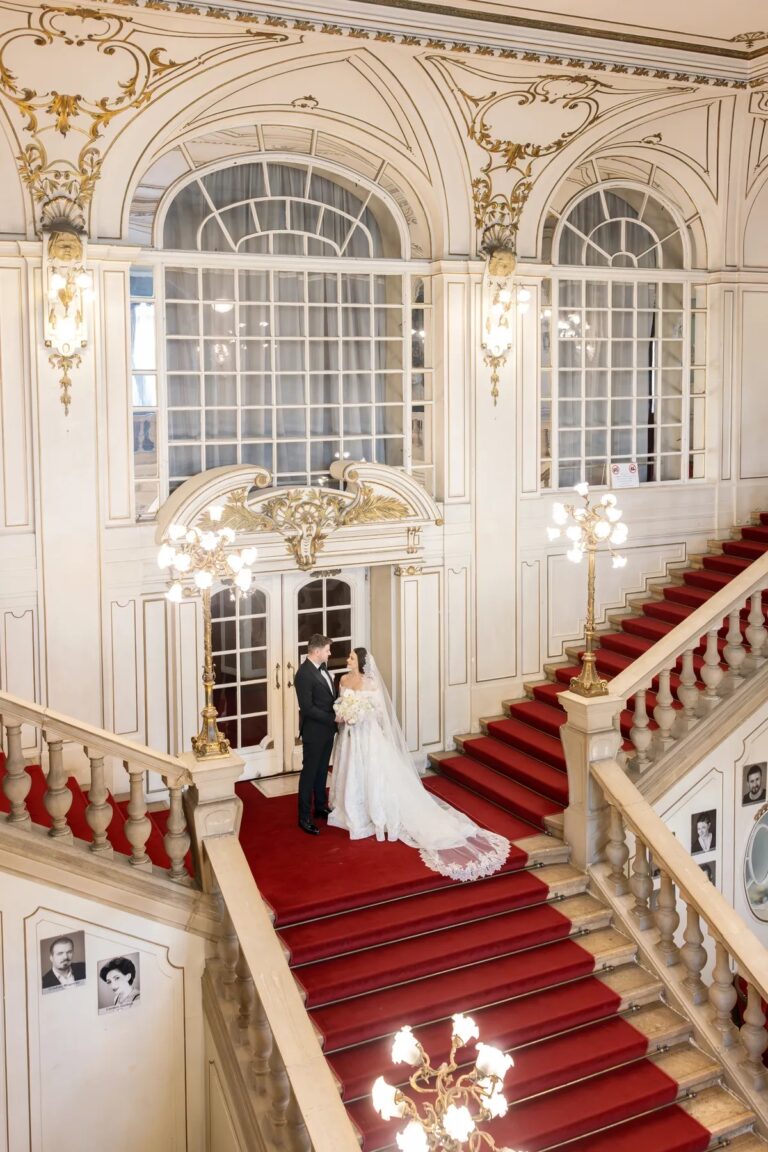 Couple on the red-carpeted staircase of a grand hall, Geta Ungurean Agency