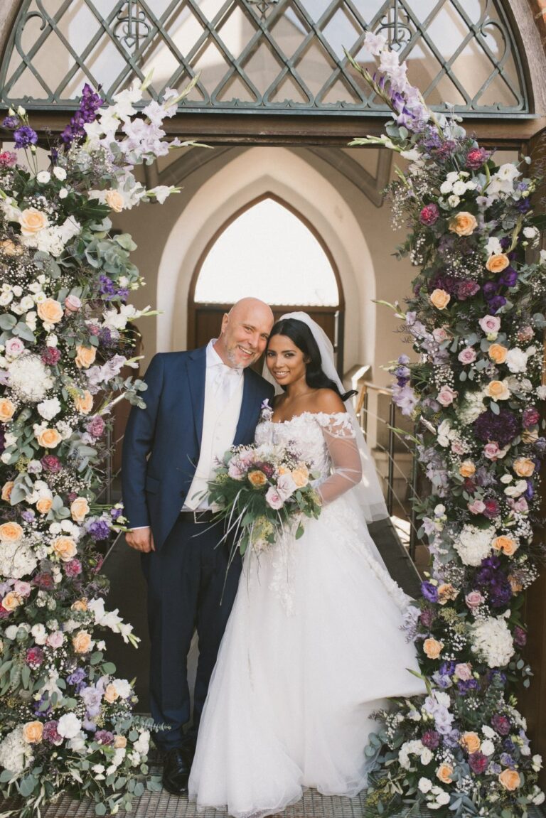 Couple beneath a floral arch at Schloss Leopoldskron, Salzburg, Getting Married In Austria