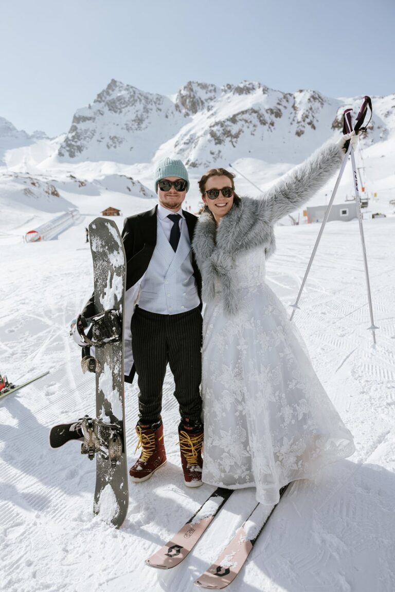 Couple in wedding attire with skis and snowboard, Tyrol, Getting Married In Austria