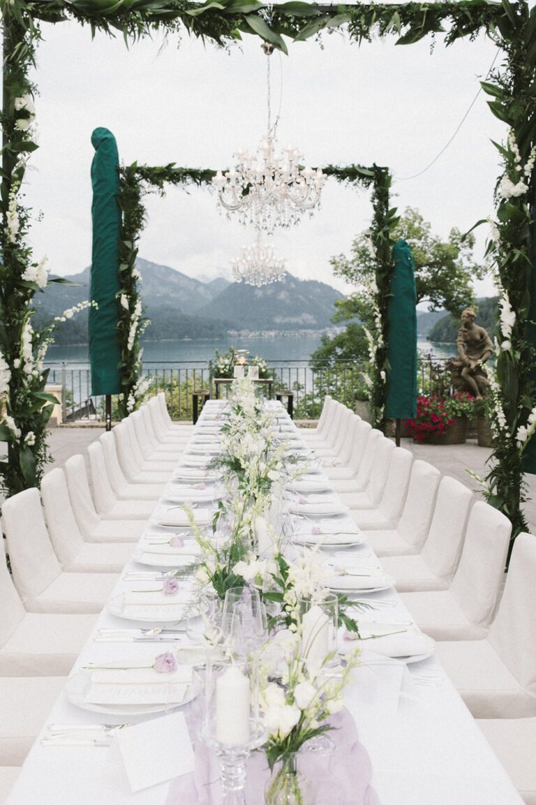 Long dinner table framed by greenery with views over Lake Fuschl, Getting Married In Austria
