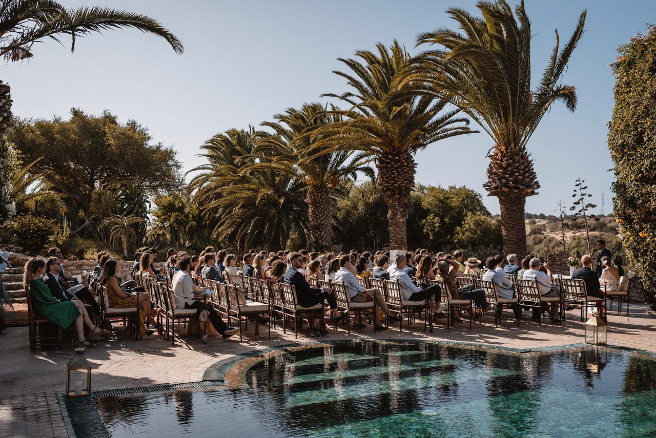 Guests gathered beside the pool and palms for a ceremony at Le Jardin des Douars, Essaouira, Giandomenico Cosentino Photography
