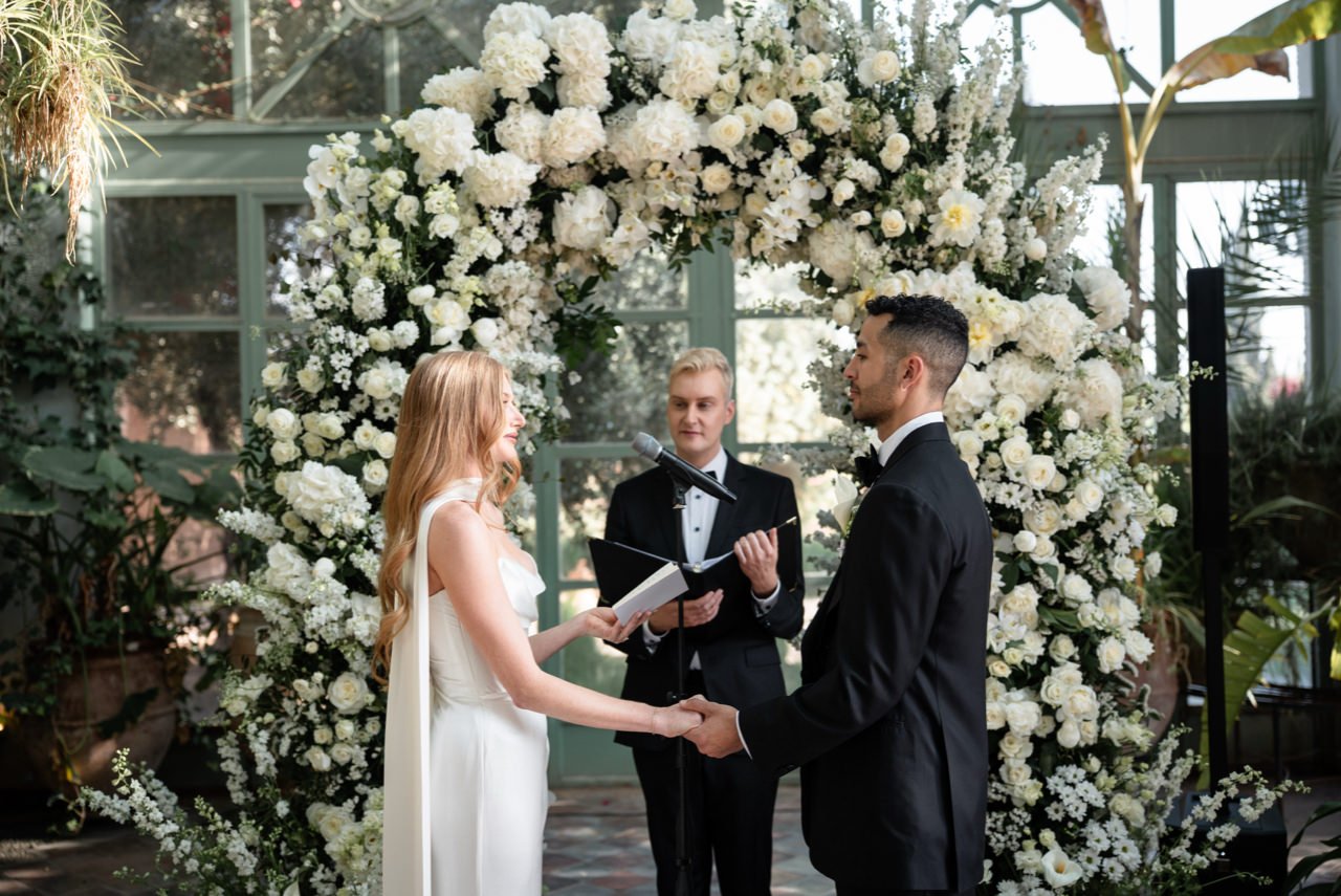 Vows beneath a white flower arch in the glasshouse at Beldi Country Club, Marrakech, Giandomenico Cosentino Photography