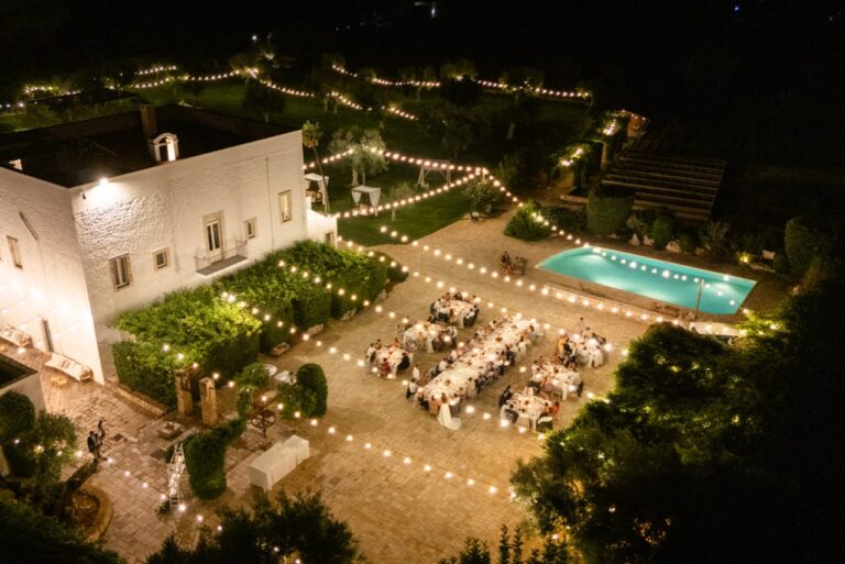 An aerial view of a reception under strings of lights beside a white masseria in Puglia, Giandomenico Cosentino Photography