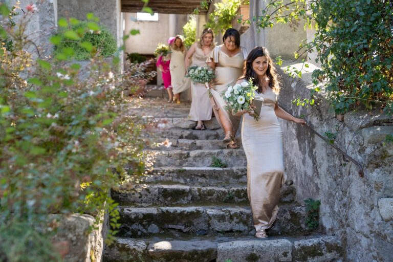 Bride and bridesmaids coming down garden steps at Borgo di Tragliata, Giuliano Bausano