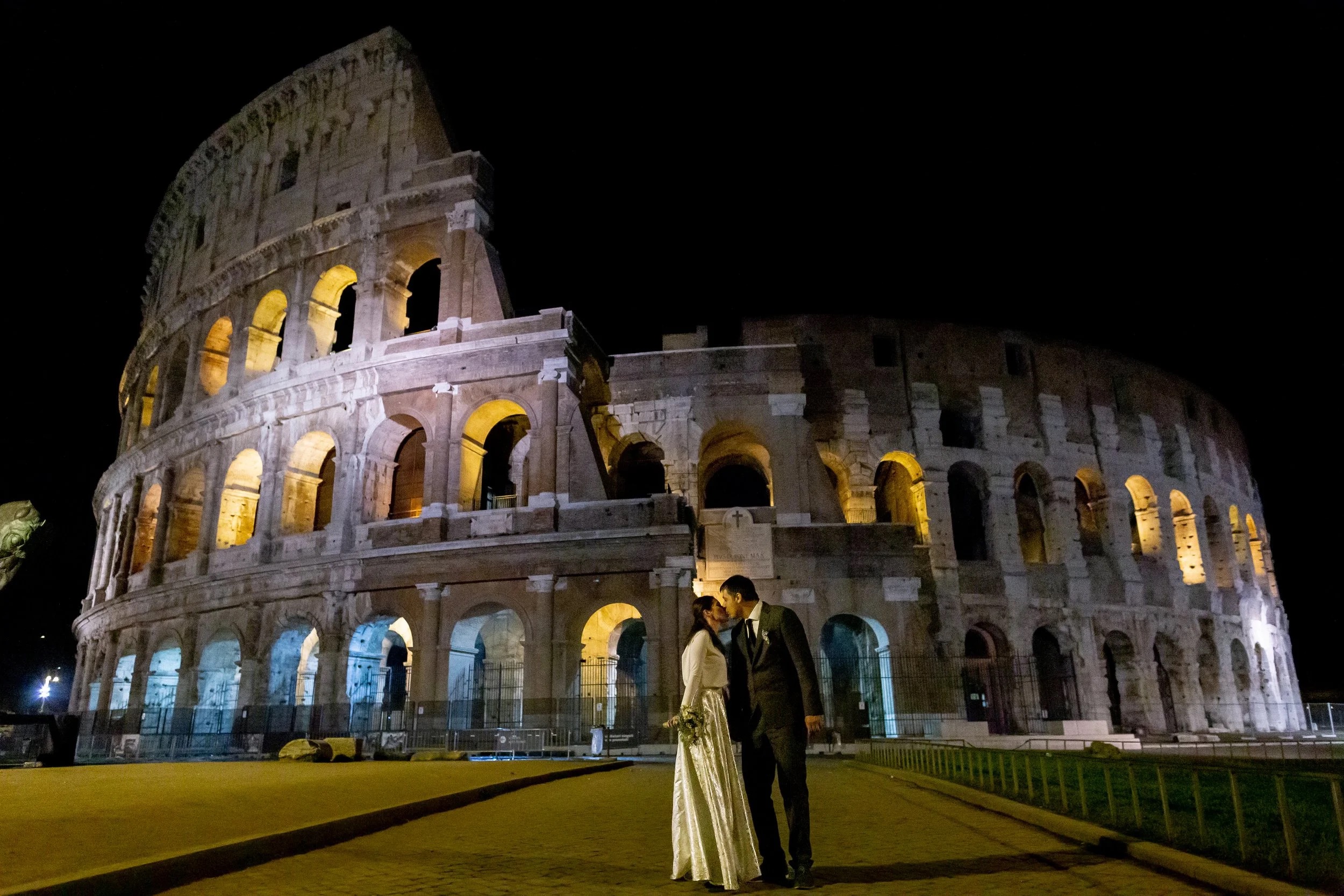 A couple at night in front of the floodlit Colosseum in Rome, Giuliano Bausano