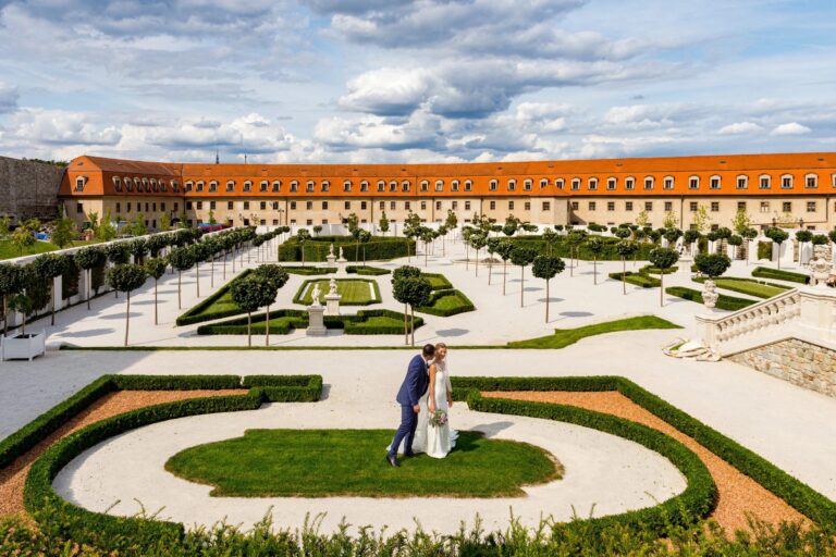 The couple in a formal Italian garden of clipped hedges in front of a historic villa, Giuliano Bausano