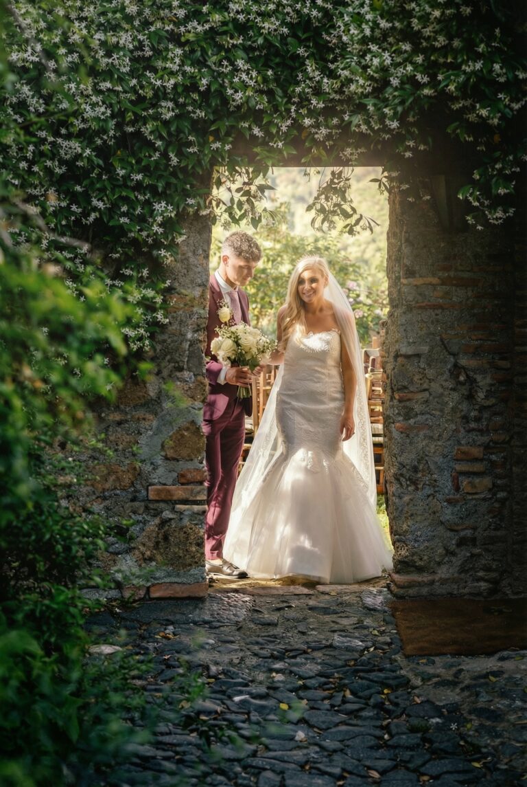 A bride framed by an ivy-covered stone doorway in a borgo garden, Giuliano Bausano