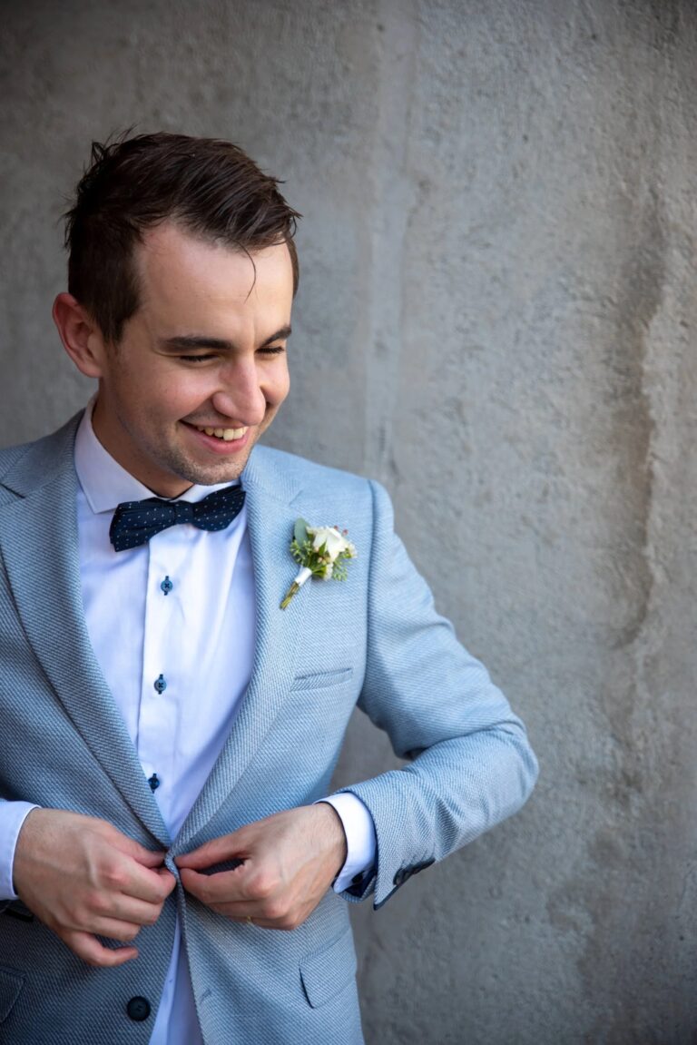 A groom fastening his jacket before the ceremony at Borgo di Tragliata, Giuliano Bausano