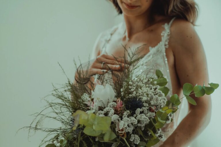 A loose wildflower bouquet held against the dress, Puglia, Giuseppe Suma Weddings