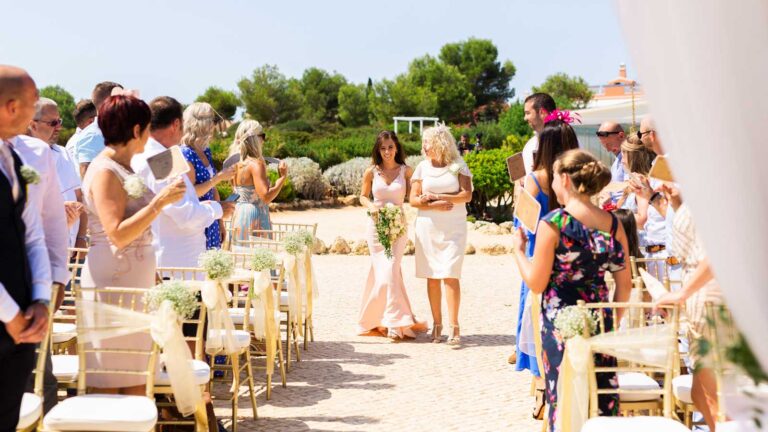 Guests taking their seats along a ceremony aisle with views over the Algarve, Glamour Algarve Weddings
