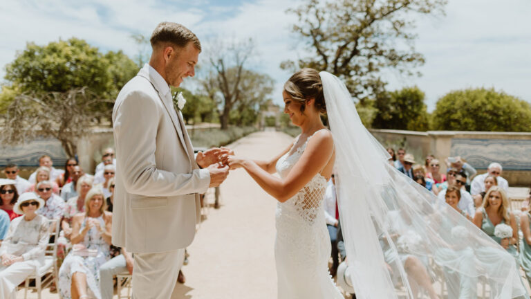 Ring exchange on a garden aisle lined with guests, Glamour Algarve Weddings