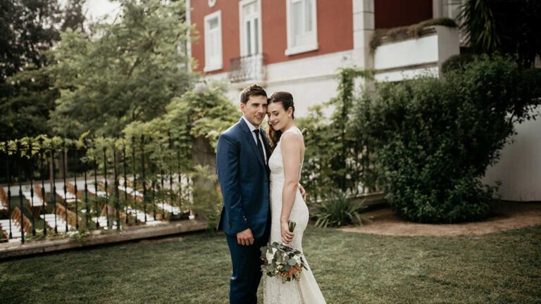 Couple in the grounds of a quinta with a red-roofed house behind, Glamour Algarve Weddings