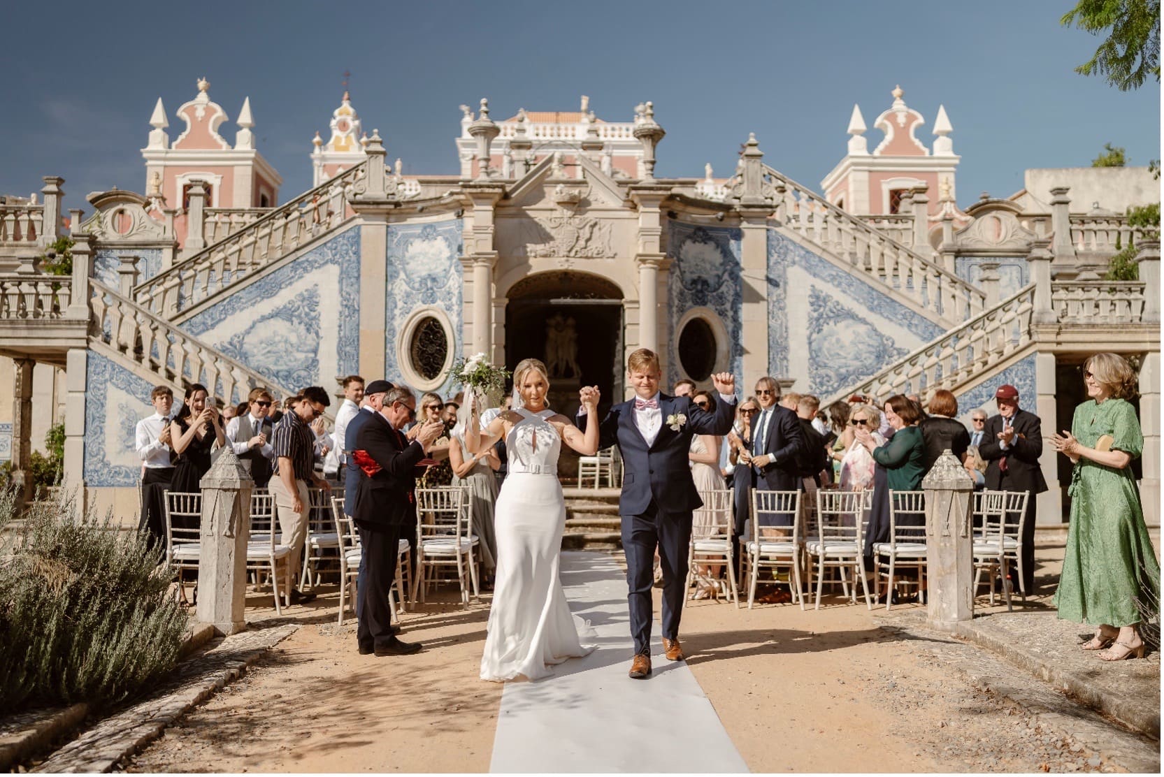 Couple and guests on the aisle before the tiled facade of Estoi Palace, Go2Wonderland