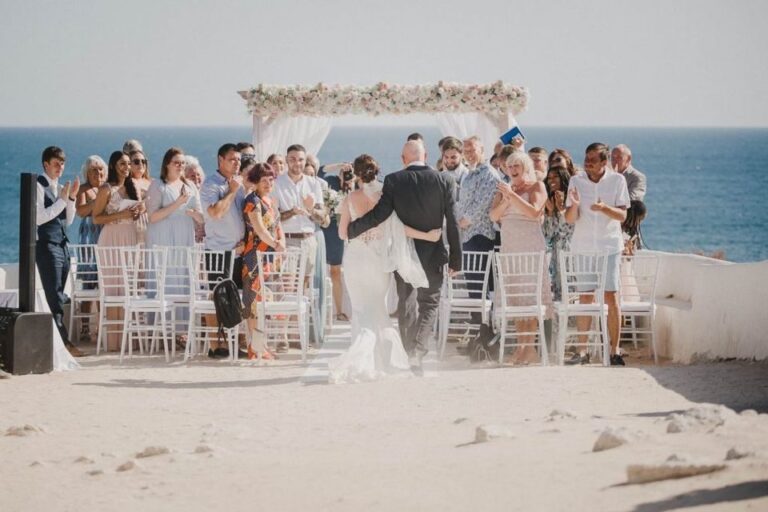 Couple walking the aisle towards a floral arch above the sea, Go2Wonderland