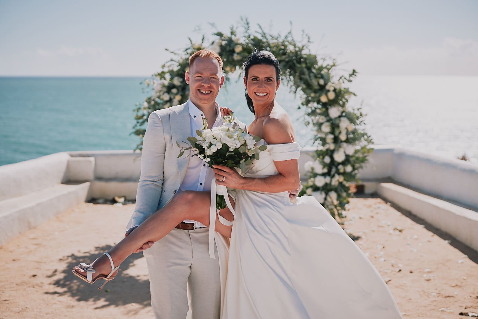 Couple under a floral ring arch on a sea-view terrace, Go2Wonderland