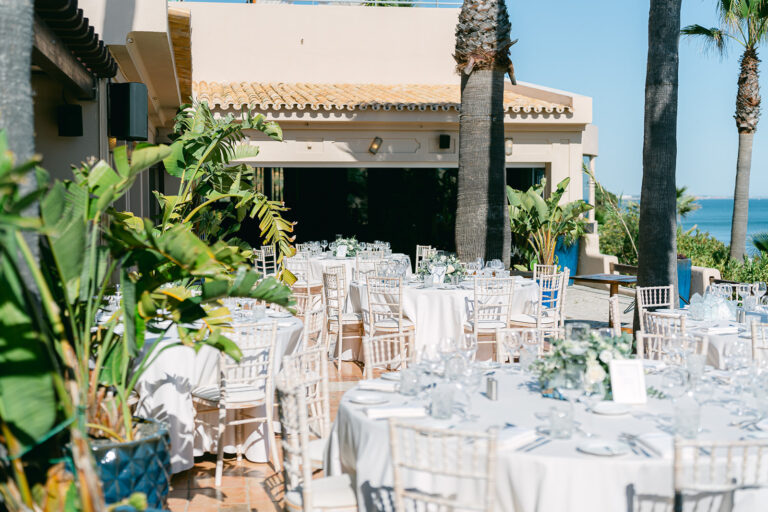 Round reception tables set in a courtyard garden with palms, Go2Wonderland