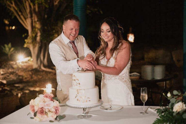 Couple cutting the wedding cake by candlelight at a garden reception, Go2Wonderland