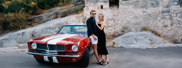 The couple beside a red vintage car the day before their wedding in Saint-Paul-de-Vence, French Riviera, Gordon Wedding Films