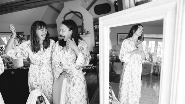 Black and white frame of bridesmaids laughing while getting ready, Gorgeous Films