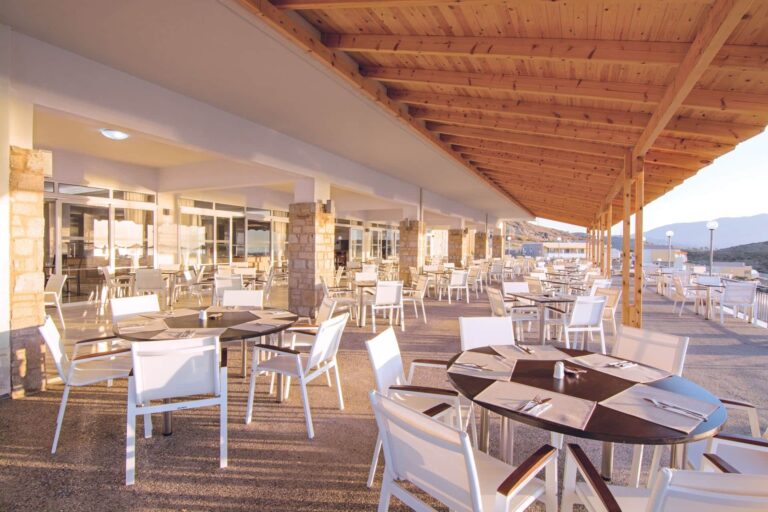A restaurant terrace with wooden tables, Grand Blue Kos Hotel