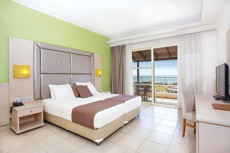 A room with a balcony and a green wall, Grand Blue Kos Hotel