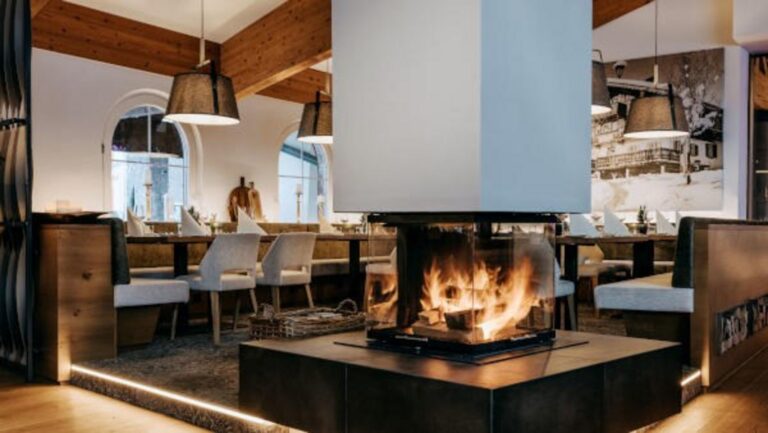 Dining room with a central fireplace, Grand Tirolia Kitzbuhel