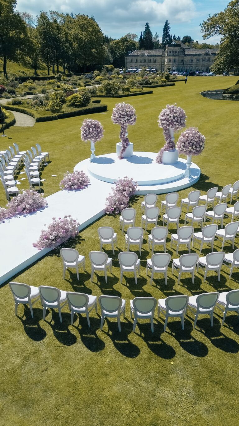 A lawn ceremony set with a round raised platform and aisle, seen from above with the Hall beyond, Grantley Hall