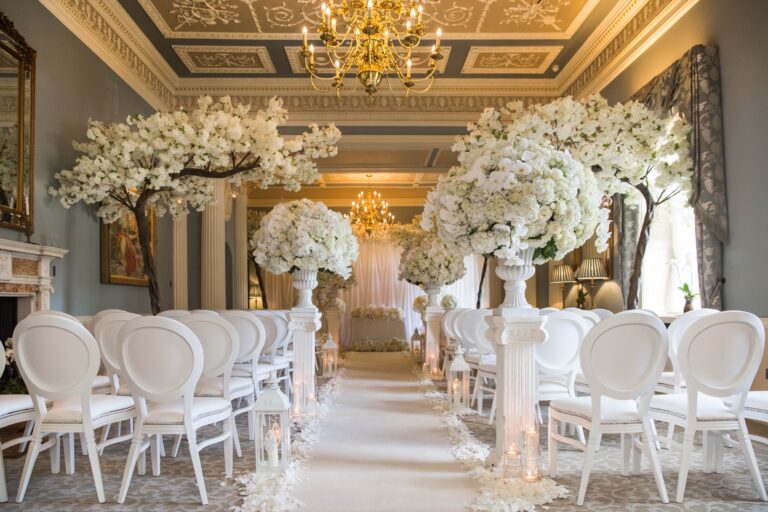 The Music Room set for a ceremony, with white chairs, blossom trees and chandeliers, Grantley Hall