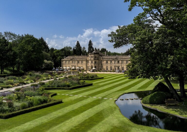 The Hall across a striped lawn, with the formal gardens and an ornamental pond in front, Grantley Hall