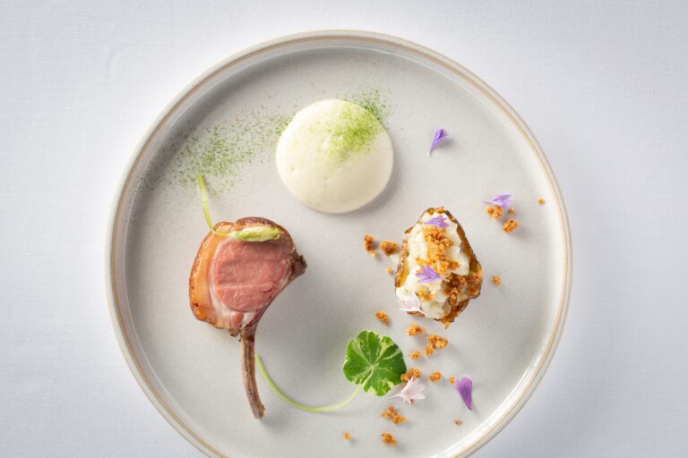 A plated lamb course with a small potato and herb garnish, Grantley Hall
