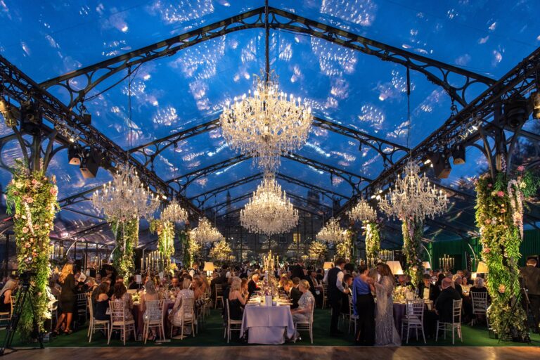 A clear-roofed marquee in the grounds with chandeliers over a large seated dinner, Grantley Hall