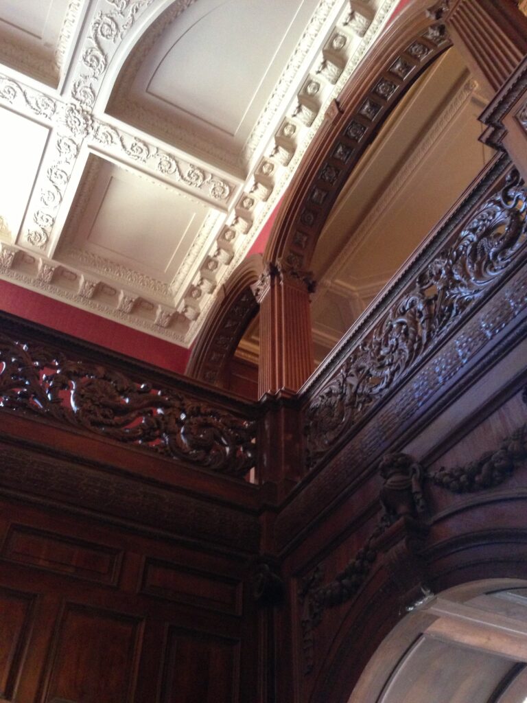 An upper gallery, red walls and white plasterwork, inside the mansion, Greystone Mansion