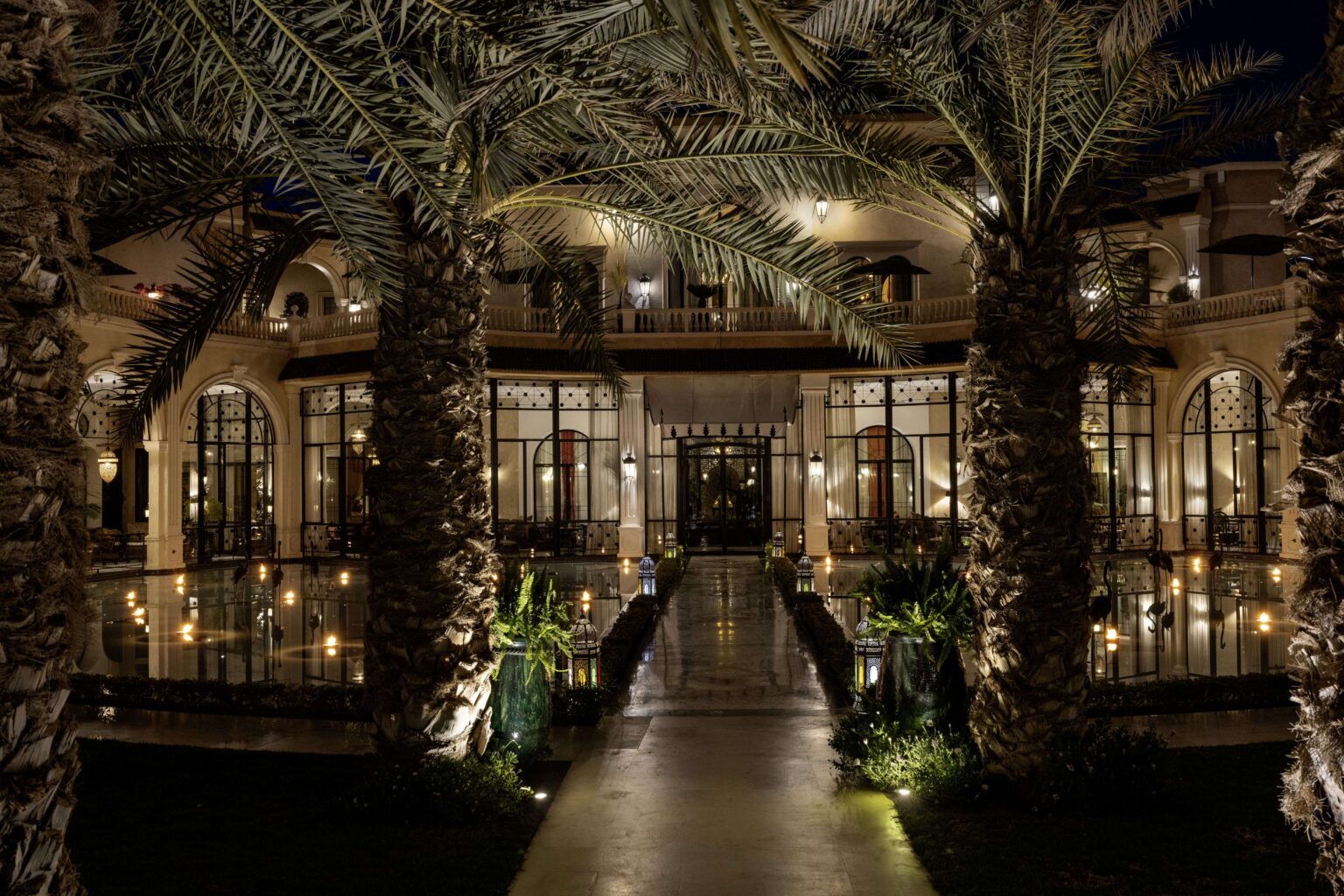 A lit path through the palm garden