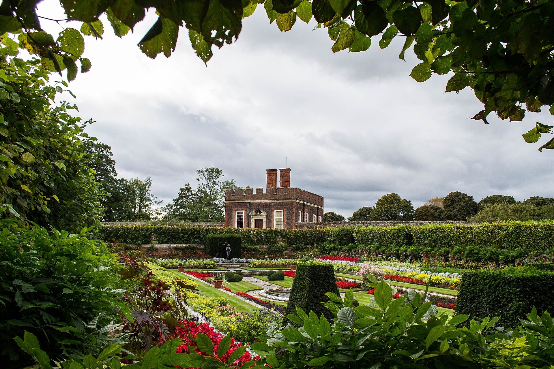 The Little Banqueting House rising beyond a formal parterre of clipped box and summer flowers, Hampton Court Palace
