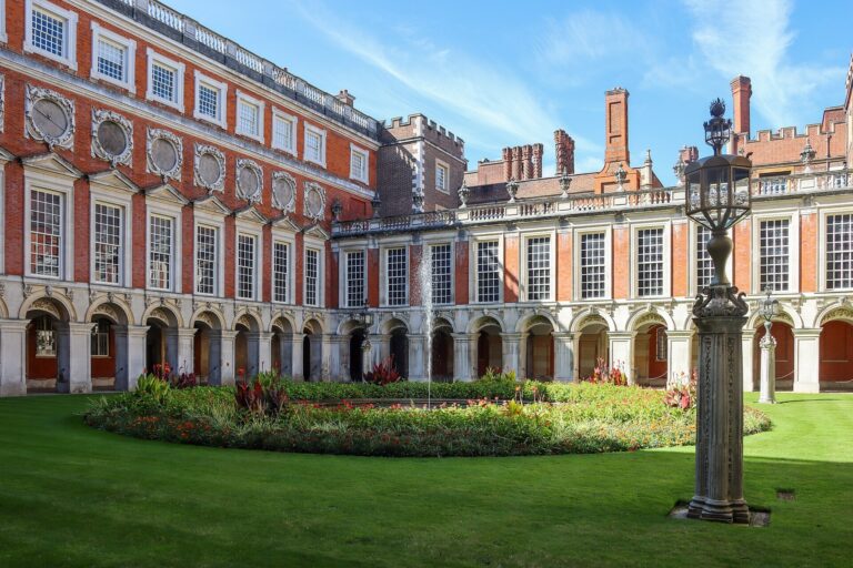 Fountain Court in sunlight, a lamp standard beside a bed of summer flowers, Hampton Court Palace
