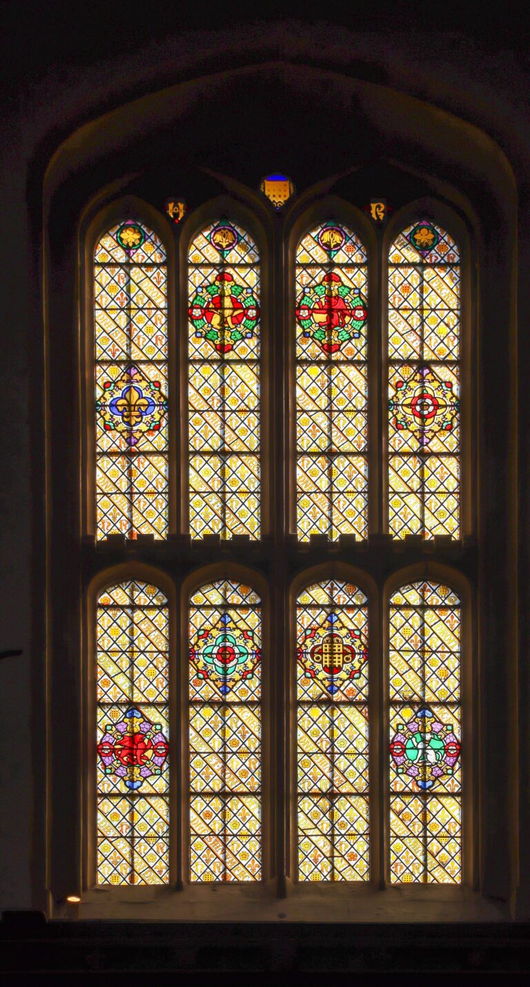 A tall Gothic window, heraldic panels lit from without, Hampton Court Palace