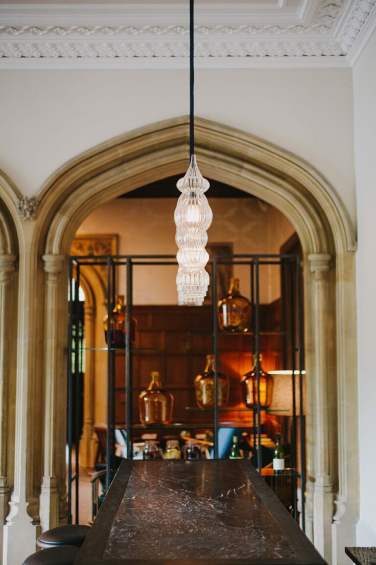 A vaulted interior hallway, a glass lantern hanging beneath the pointed arch, Hampton Manor