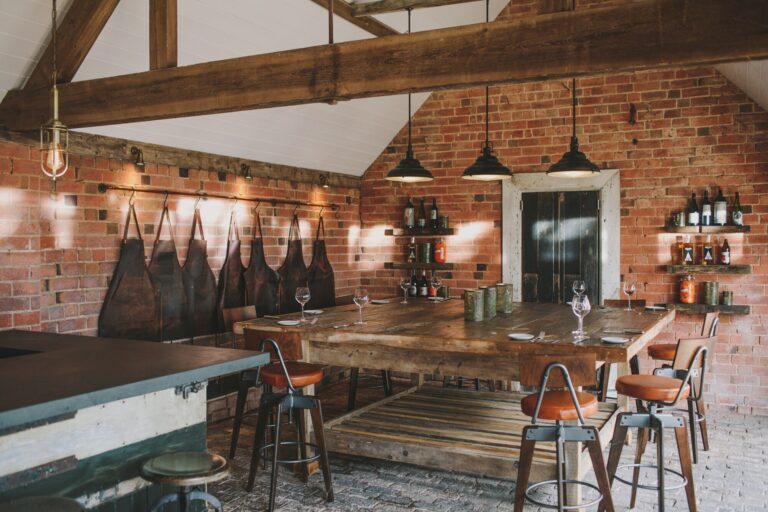 The Birches, the estate rustic ceremony barn, brick walls, exposed beams and a long refectory table, Hampton Manor