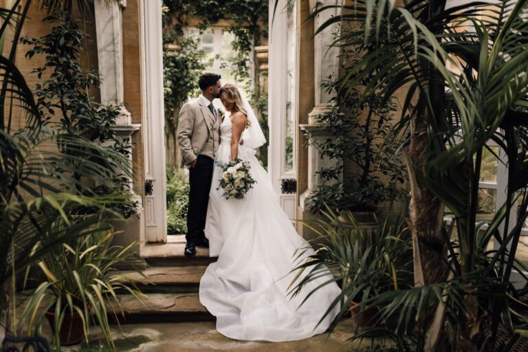 A couple in a doorway of the conservatory among palms, Harlaxton Manor