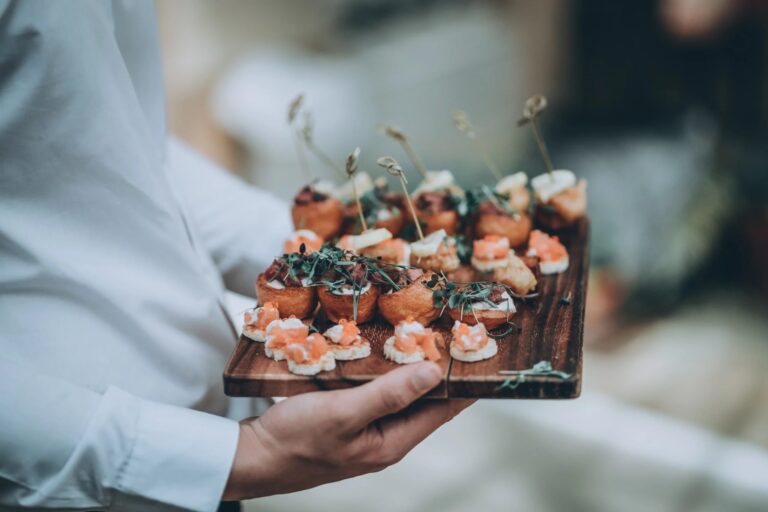 A tray of canapés carried on a wooden board by a waiter, Harlaxton Manor