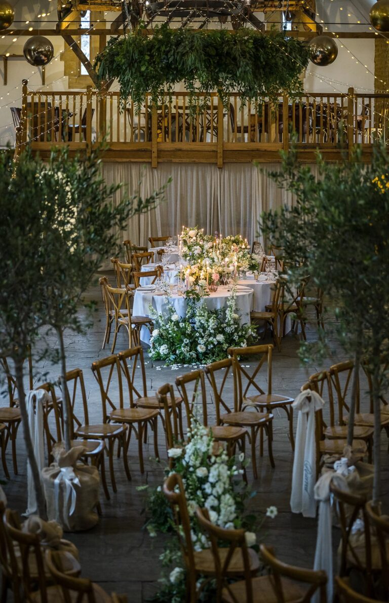 The Tithe Barn dressed for a ceremony, foliage above the balcony, Haselbury Mill