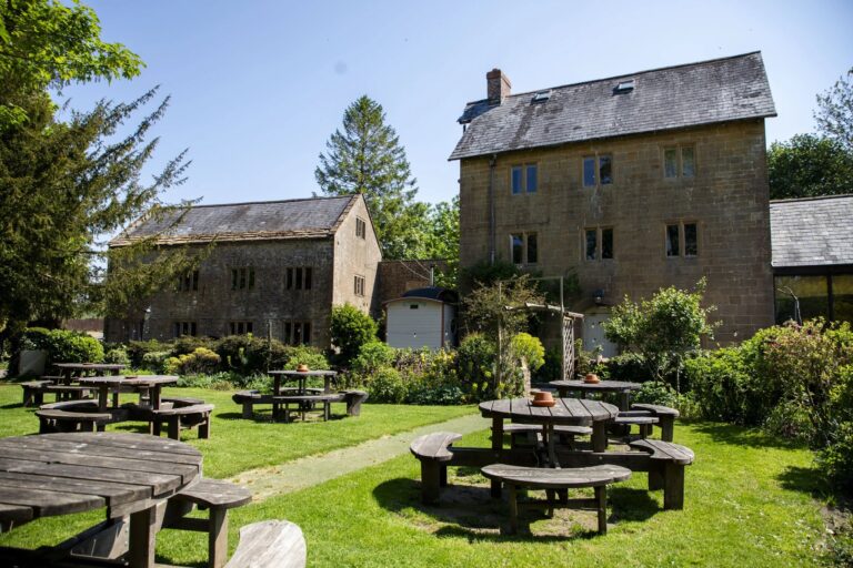 The mill buildings and garden with picnic tables, Haselbury Mill