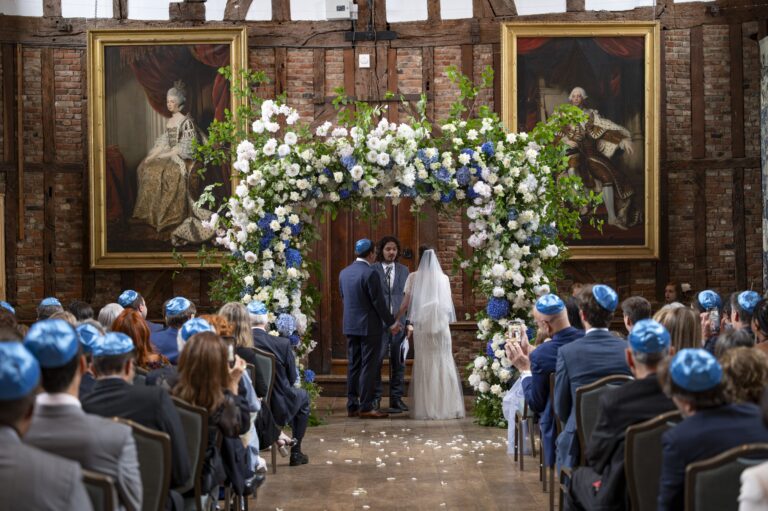 A ceremony beneath a floral arch in the Old Palace, Hatfield House