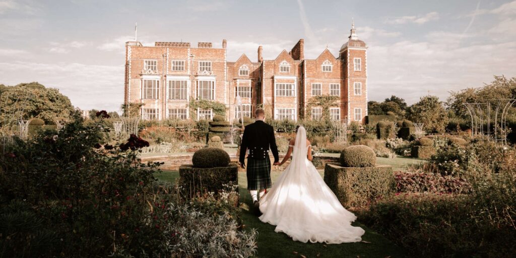 A couple in the gardens with Hatfield House behind, Hatfield House