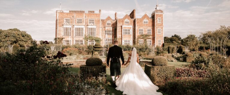A couple walking towards Hatfield House at sunset, Hatfield House