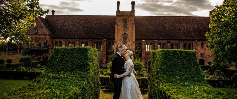 A couple in front of the Old Palace and the Knot Garden, Hatfield House