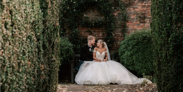 A couple seated between clipped yew hedges, Hatfield House