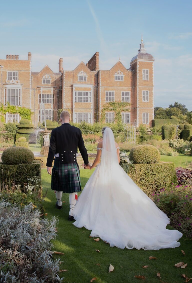 A couple walking in the garden towards Hatfield House, Hatfield House
