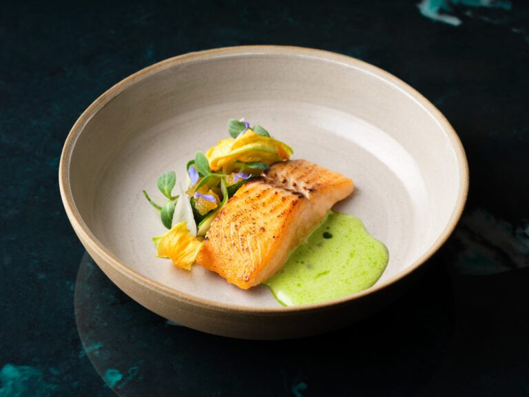 Salmon with a bright herb sauce and edible flowers in a stoneware bowl, Haycock Manor
