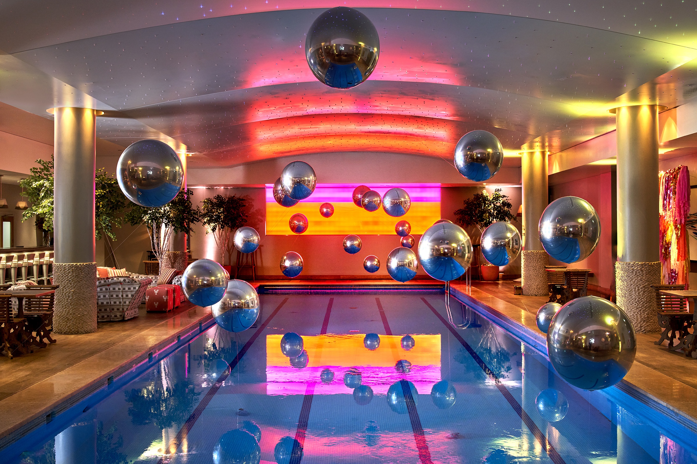 The pool room styled for an event, a mirror-ball above the water, Haymarket Hotel